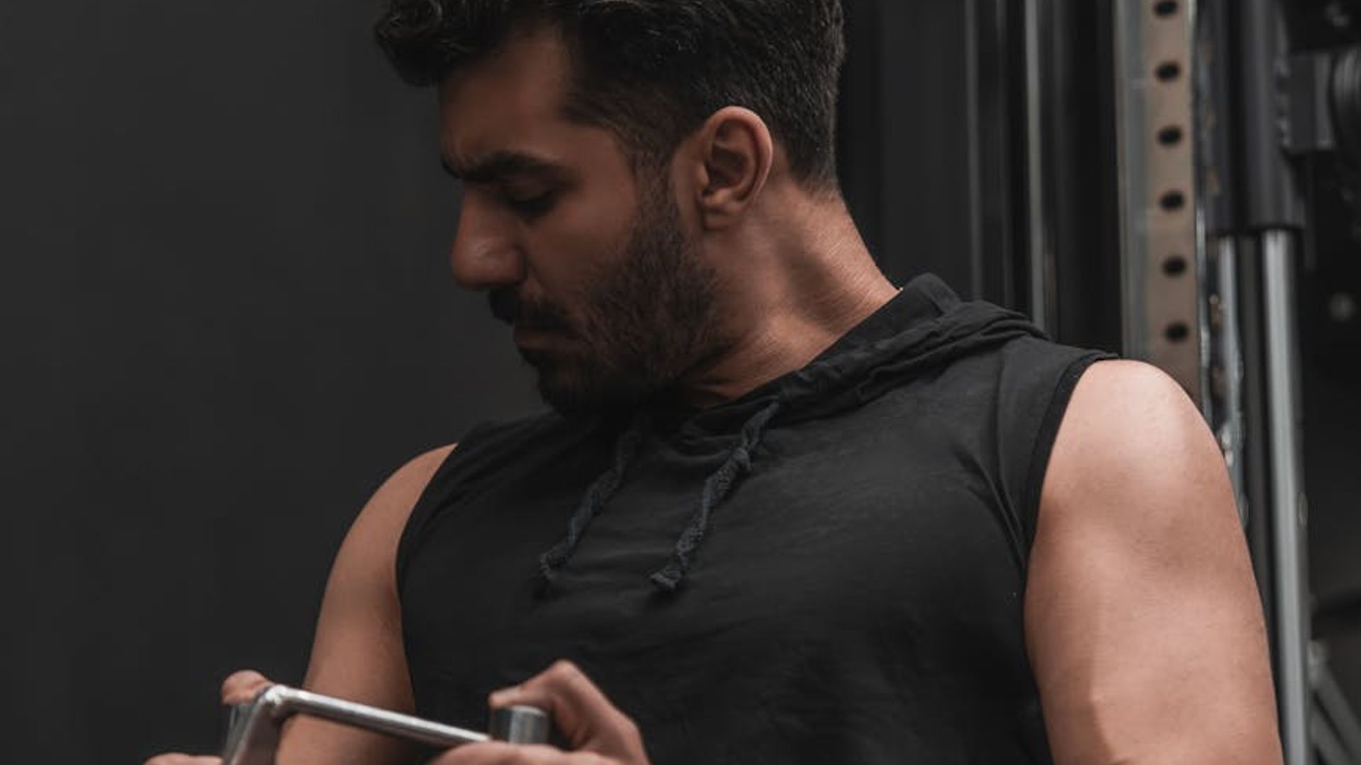 Strong man training in a dark gym with blue lighting